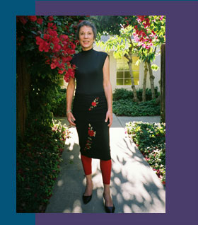 Judith Claire counselor and coach, standing in a garden with lovely flowers